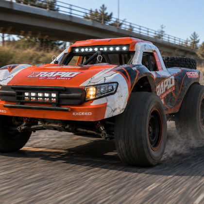 Trophy truck télécommandé Rapid 4×4 1/16 orange en glisse sur une route, barre de LED allumée