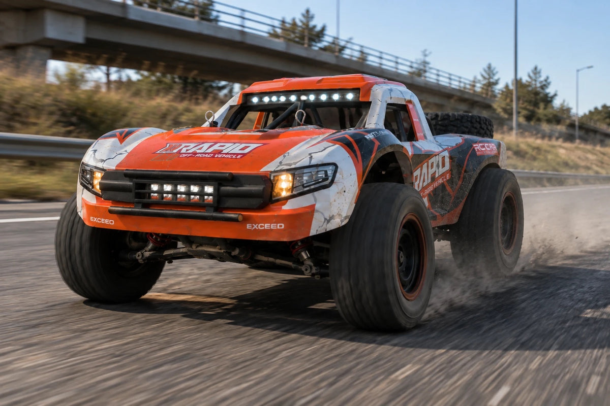 Trophy truck télécommandé Rapid orange lancé sur une route de montagne