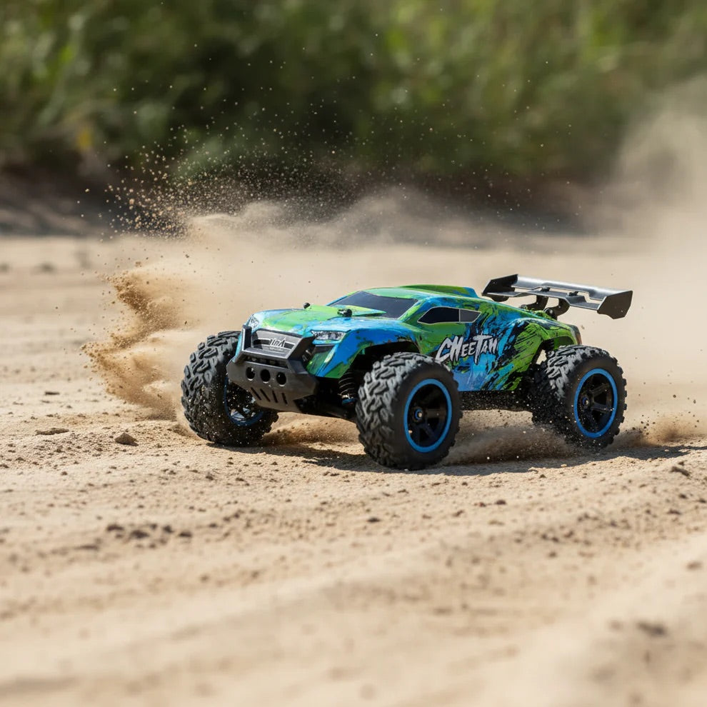 Voiture télécommandée Cheetah 4×4 1/14 en dérapage sur une piste de sable, gerbe de sable soulevée