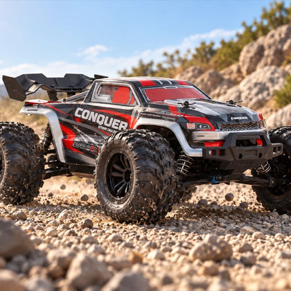 Conquer 4×4 1/16 en carrosserie rouge, à l’attaque sur un chemin de gravier, rochers et ciel dégagé