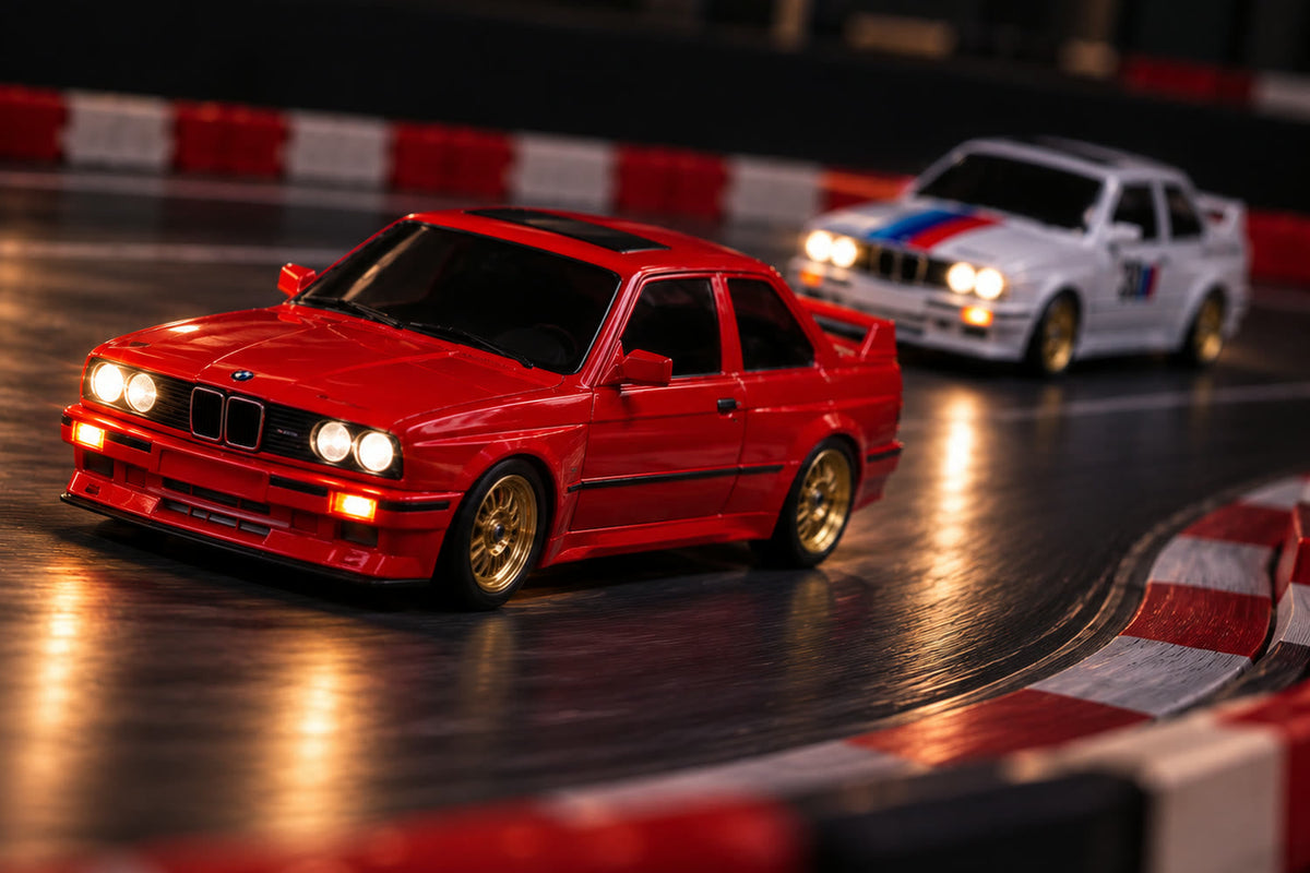 Drift Origin rouge en tête devant la blanche, sur une piste d'intérieur