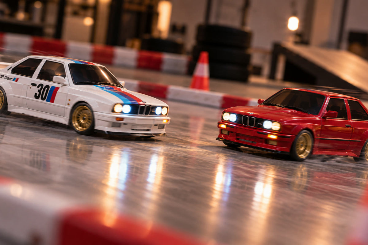 Drift Origin blanche et rouge côte à côte sur une piste d'intérieur